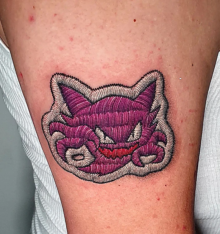 Haunter morado tatuado como un parche bordado, con el hilo a la vista