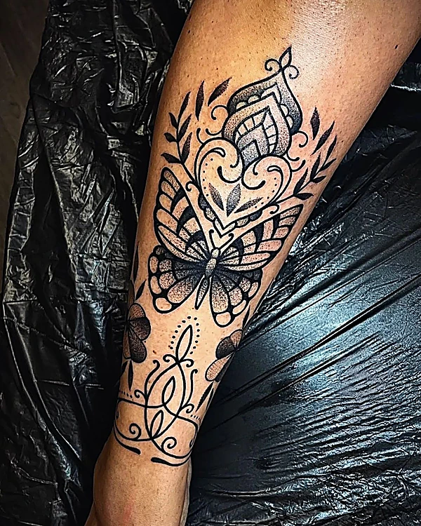 Mariposa y mandala en puntillismo en el antebrazo